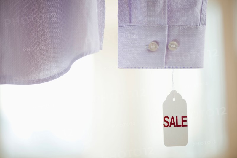 Close up of shirt cuff with sale tag.
