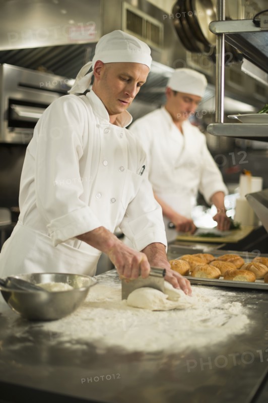 Chef cutting pastry to make rolls.