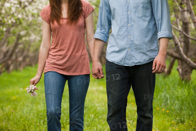 USA, Utah, Provo, Young couple walking through orchard. Photo : Mike Kemp