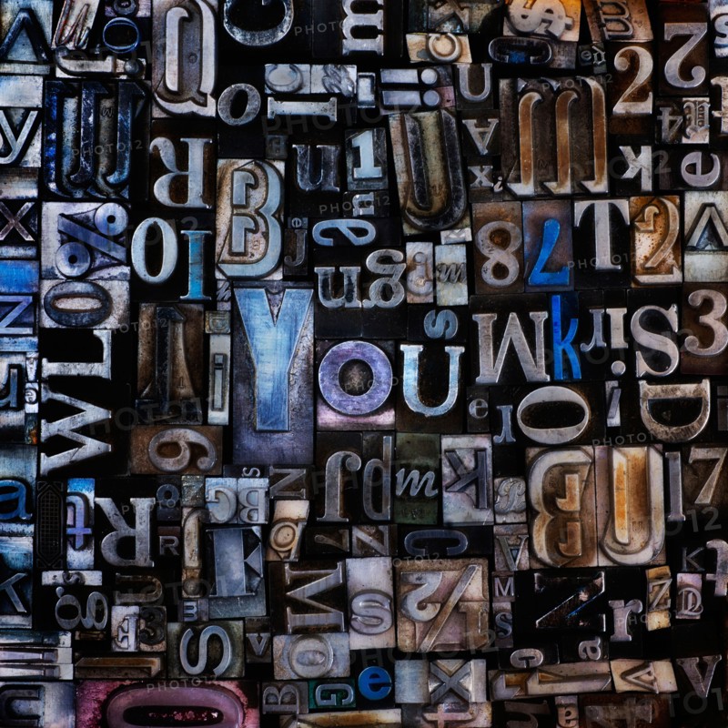 Assortment of printing blocks with word YOU in the middle of picture.