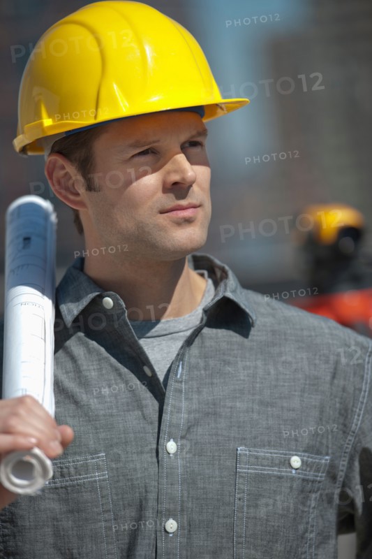 Portrait of worker holding blueprint.