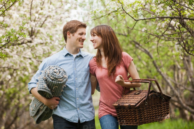 Young couple with picnic basket in orchard. Photo : Mike Kemp