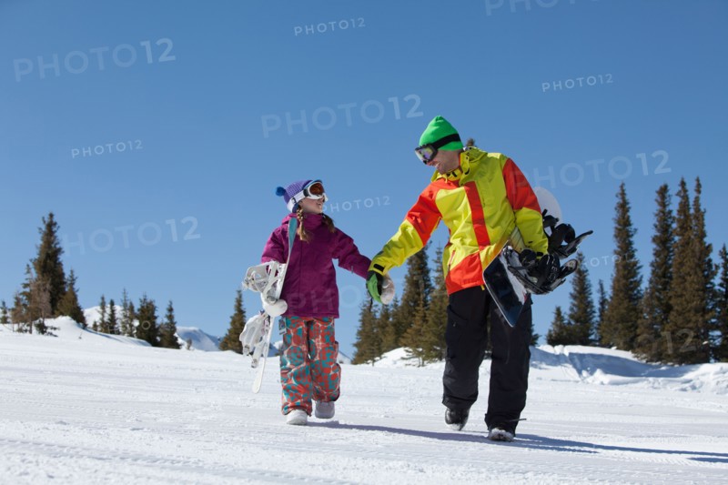 USA, Colorado, Telluride, Father and daughter (10-11) walking with snowboards in winter scenery. Photo : db2stock