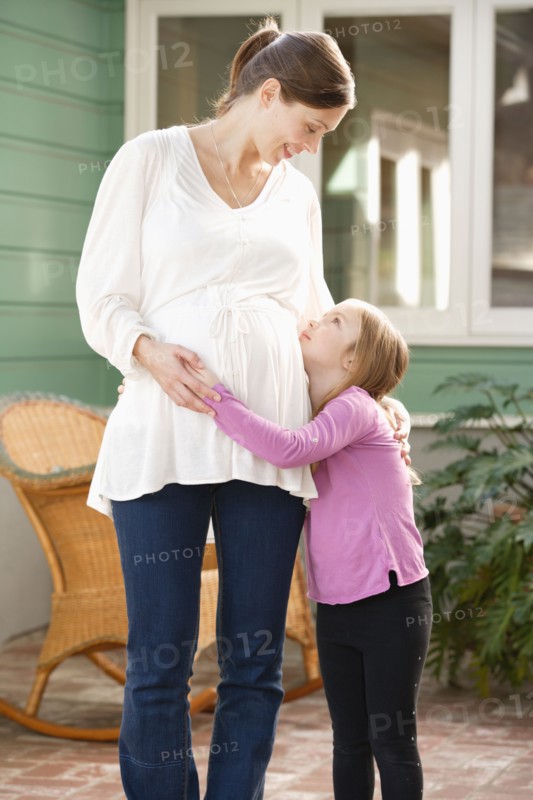 Expectant mother embracing daughter (4-5). Photo : Rob Lewine