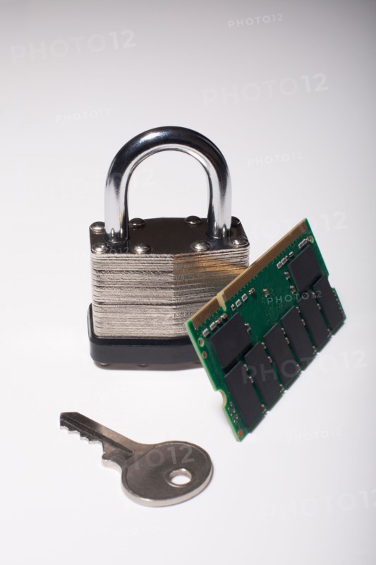 Close-up studio shot of silver padlock with key and computer chip. Photo : Winslow Productions