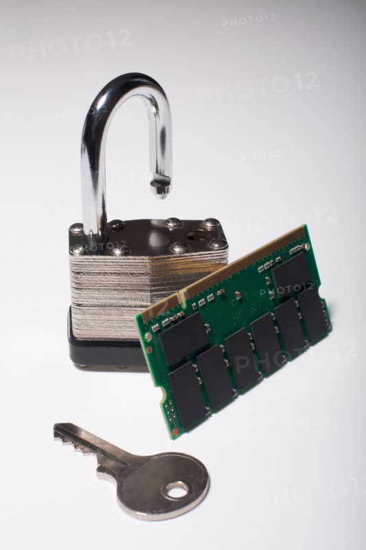 Close-up studio shot of silver padlock with key and computer chip. Photo : Winslow Productions