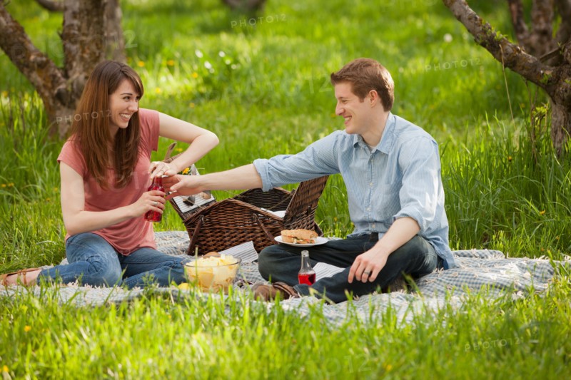 USA, Utah, Provo, Young couple having picnic in orchard. Photo : Mike Kemp