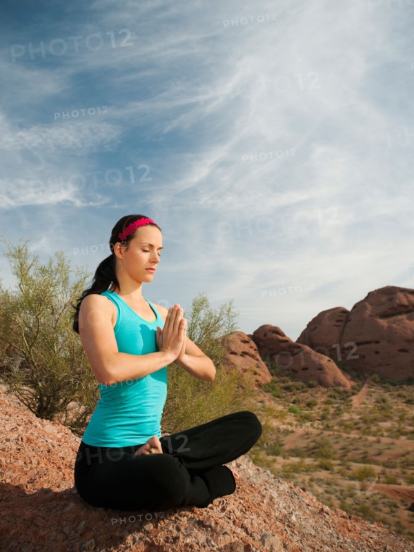 USA, Arizona, Phoenix, Young woman practicing yoga on desert.