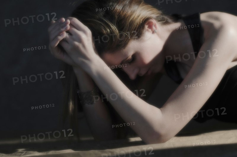 Woman with hands clasped, relaxing.