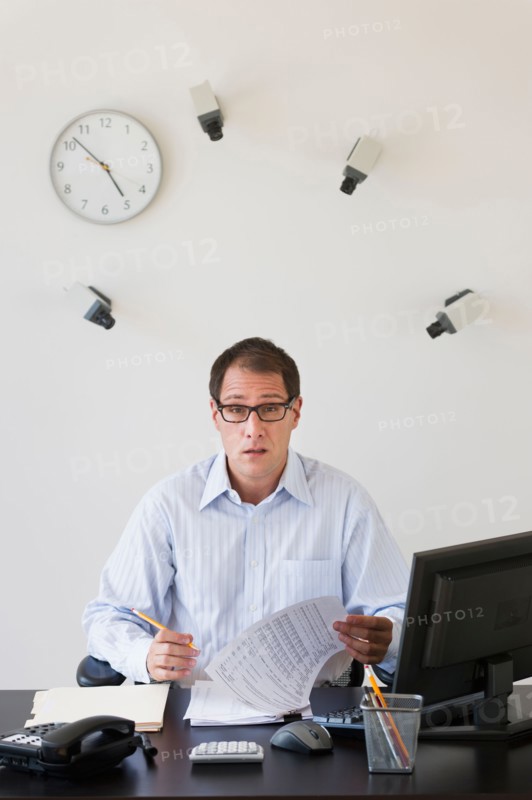 Businessman under surveillance of security cameras.