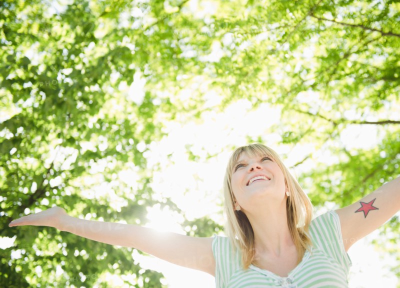USA, New York, Williamsburg, Brooklyn, Portrait of smiling woman under green tree. Photo : Jamie Grill