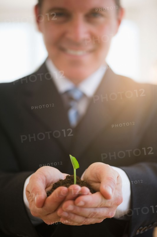 Businessman holding seedling. Photo: Jamie Grill