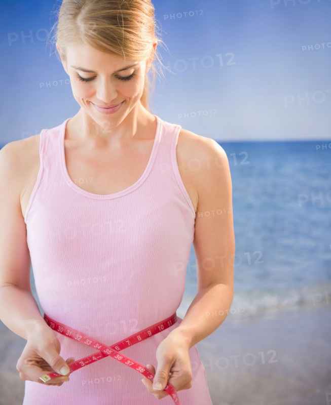 Woman measuring her waist. Photo : Jamie Grill