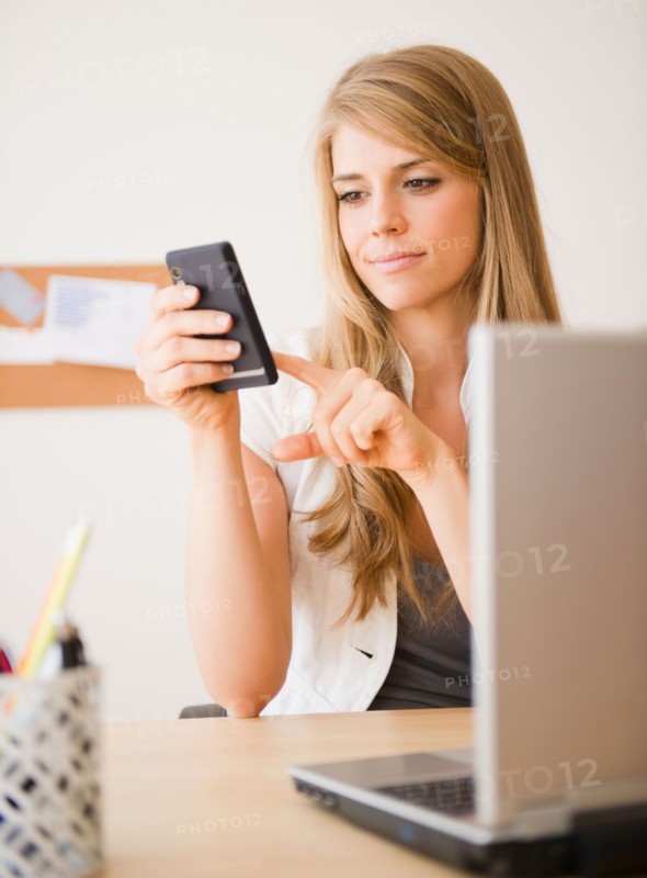 Businesswoman working at desk in office. Photo : Jamie Grill