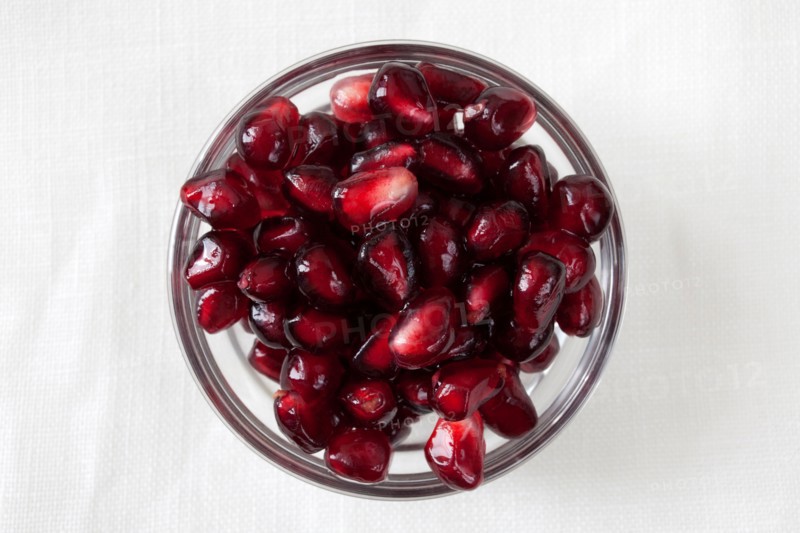 Studio shot of pomegranate (Punica granatum) seeds in bowl. Photo: Winslow Productions