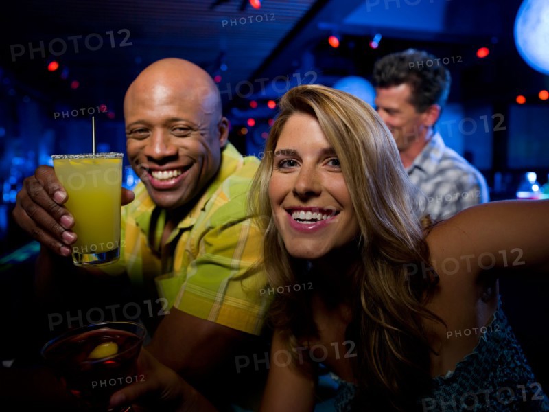 Friends enjoying drinks at bar. Photo: db2stock