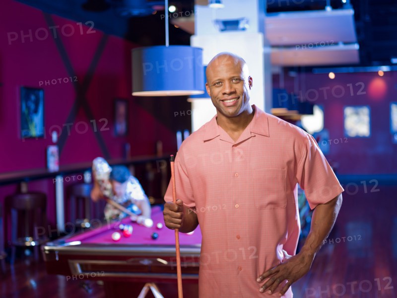 Men enjoying game of pool at bar. Photo : db2stock