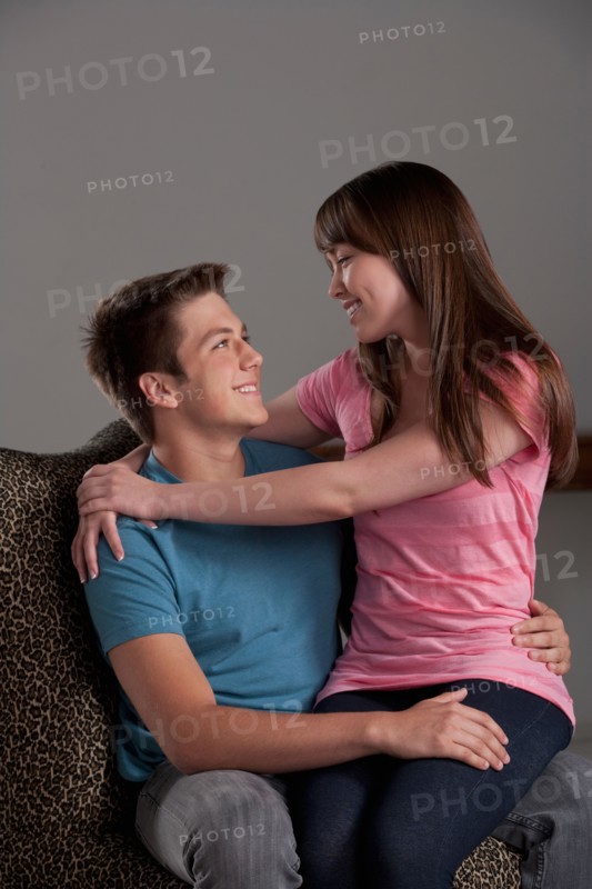 Portrait of teenage boy (16-17) embracing with young woman, studio shot. Photo : Rob Lewine