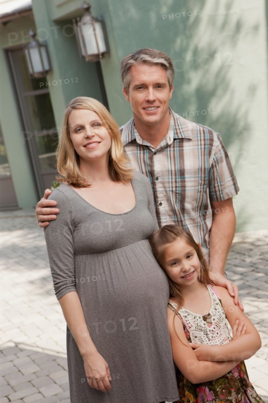 Pregnant mother, father and daughter (6-7) posing for portrait. Photo: Rob Lewine