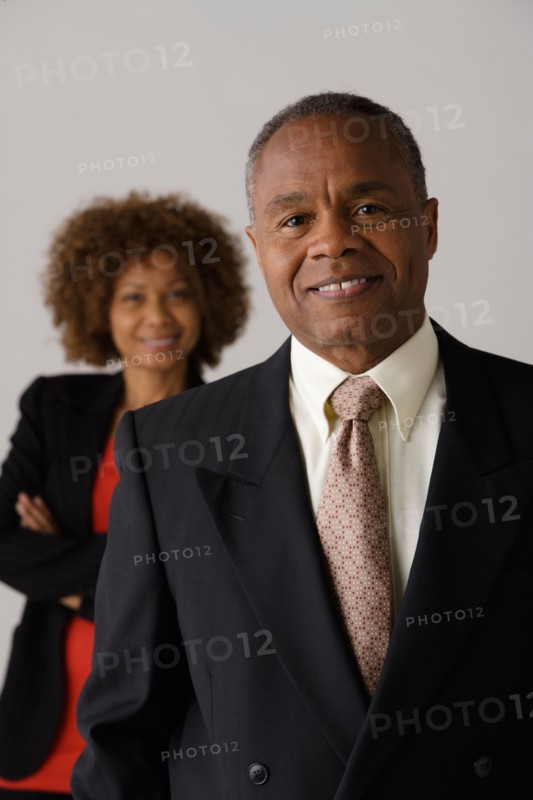 Mature business people, studio shot. Photo: Rob Lewine
