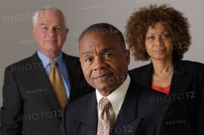 Portrait of three business people, studio shot. Photo: Rob Lewine