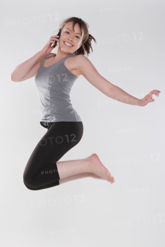 Portrait of young woman jumping, studio shot. Photo: Rob Lewine