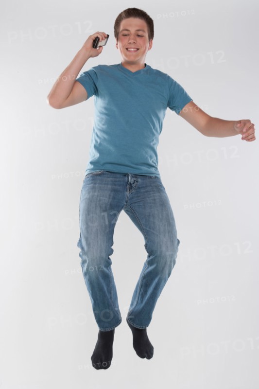 Portrait of teenage boy (16-17) jumping, studio shot. Photo : Rob Lewine