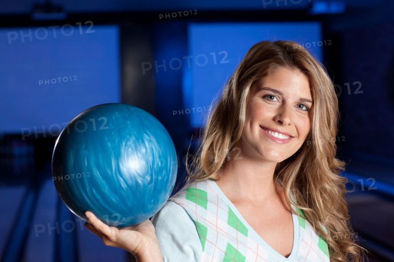 Young smiling woman holding bowling ball. Photo : db2stock