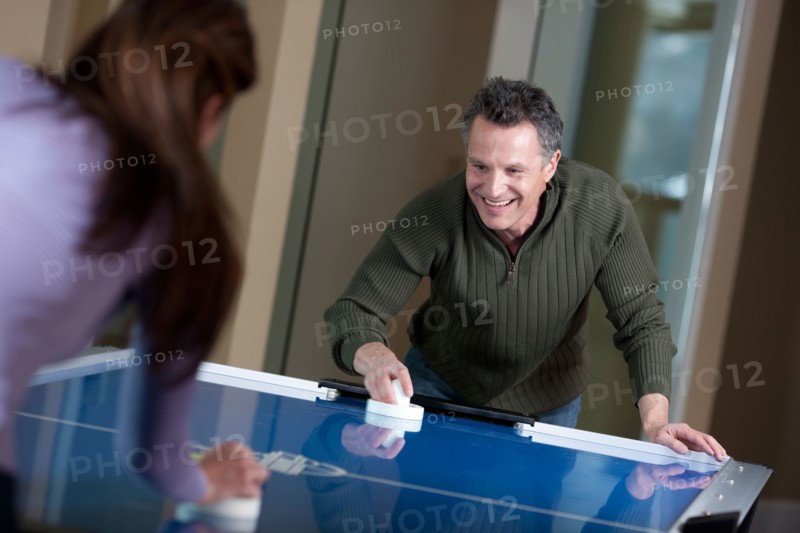 Couple playing air hockey. Photo: db2stock