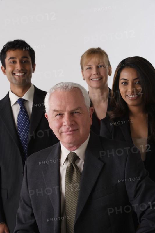 Portrait of four business people, studio shot. Photo : Rob Lewine