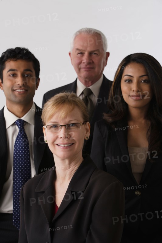 Portrait of four business people, studio shot. Photo : Rob Lewine