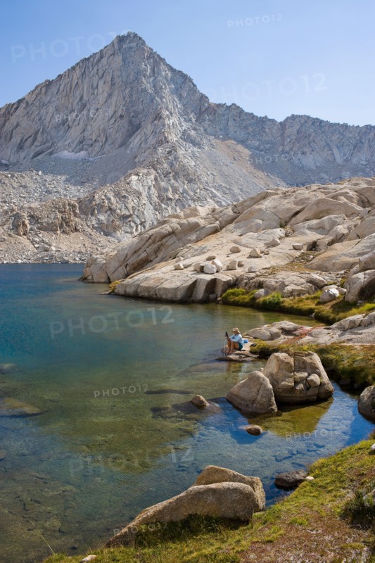 USA, California, Sequoia National Park, Five Lakes trail, Hiker sitting at edge of lake. Photo: Noah Clayton