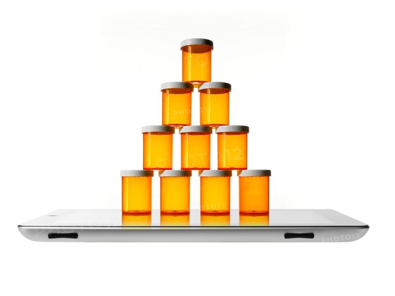 Studio shot of stack of pill bottles on digital tablet. Photo : David Arky