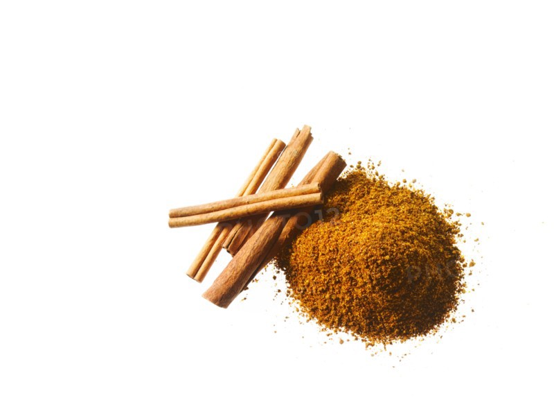 Studio shot of Ground Cinnamon and Cinnamon Sticks on white background. Photo : David Arky