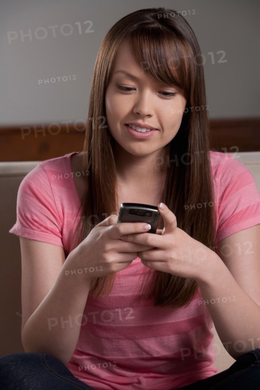 Portrait of young woman with mobile phone, studio shot. Photo: Rob Lewine