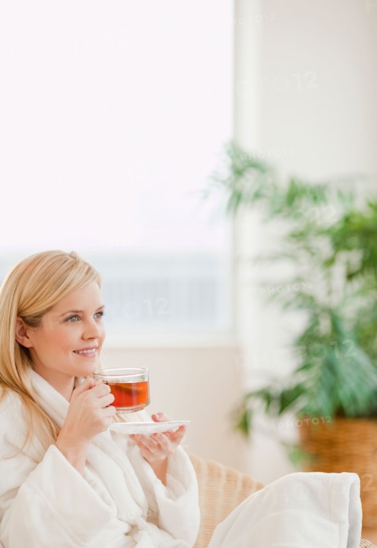 Young woman in bathrobe drinking tea. Photo : Jamie Grill