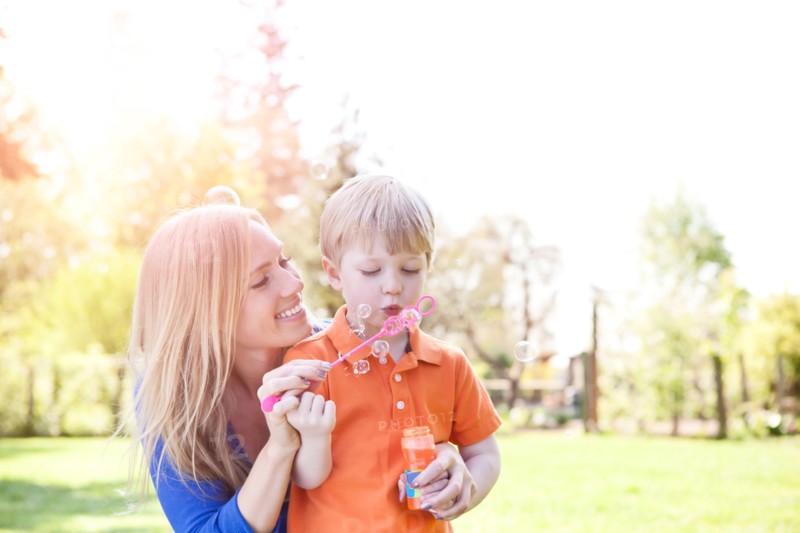 Mother and son (2-3) blowing bubbles in park. Photo: Take A Pix Media
