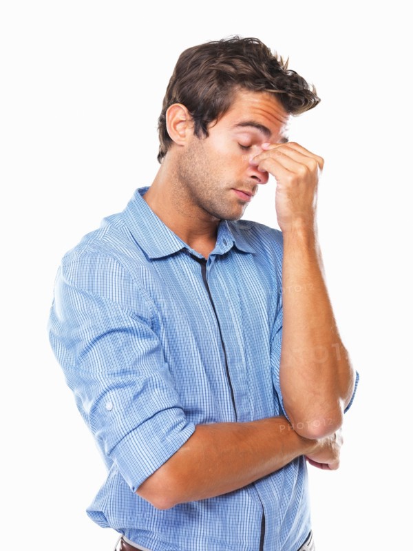 Stressed male executive standing and rubbing nose. Photo: momentimages