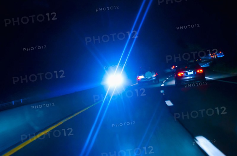 Car headlights on road at night.