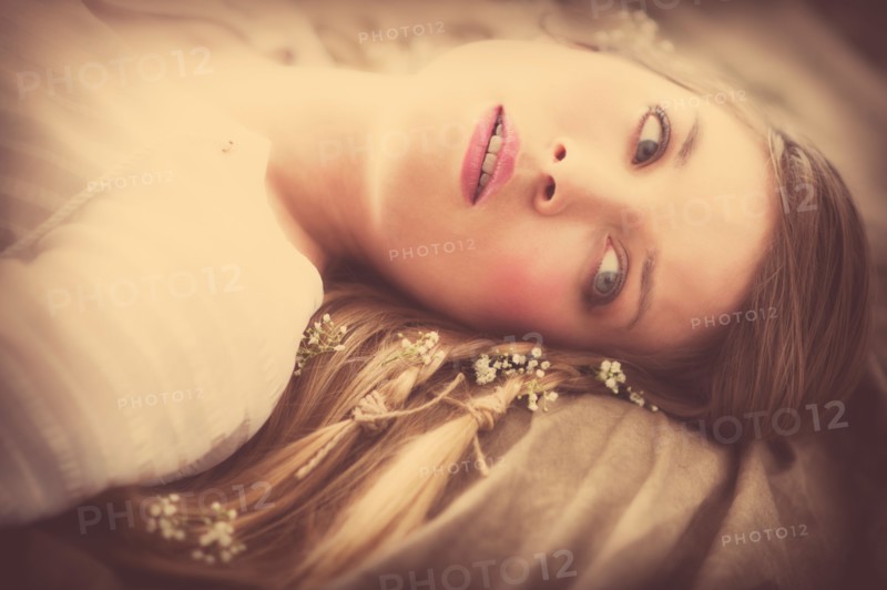 Young woman lying with flowers in hair.
