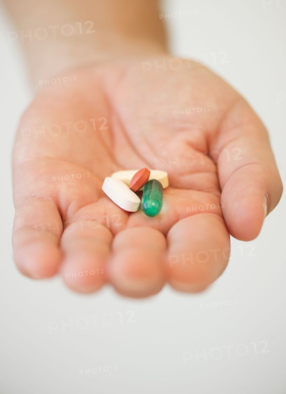 Hand holding pills.