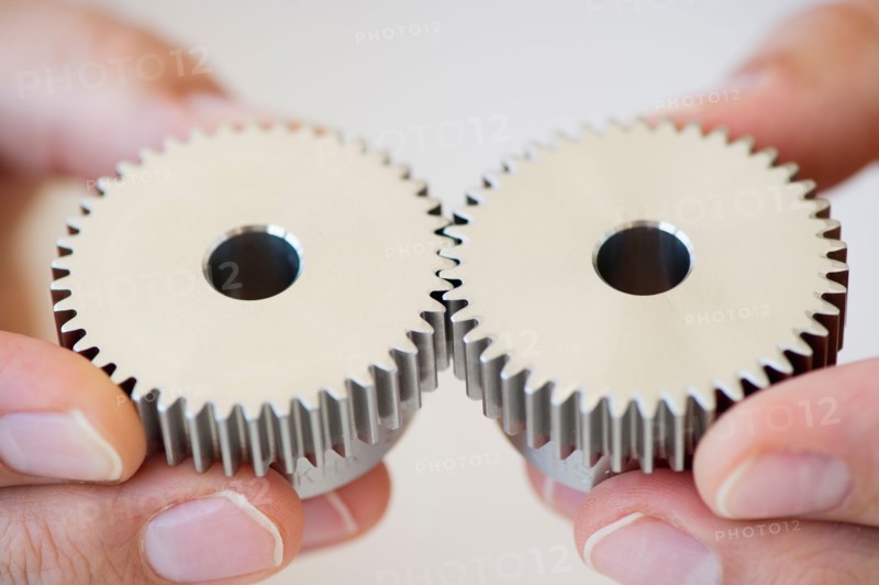 Hands holding gears.