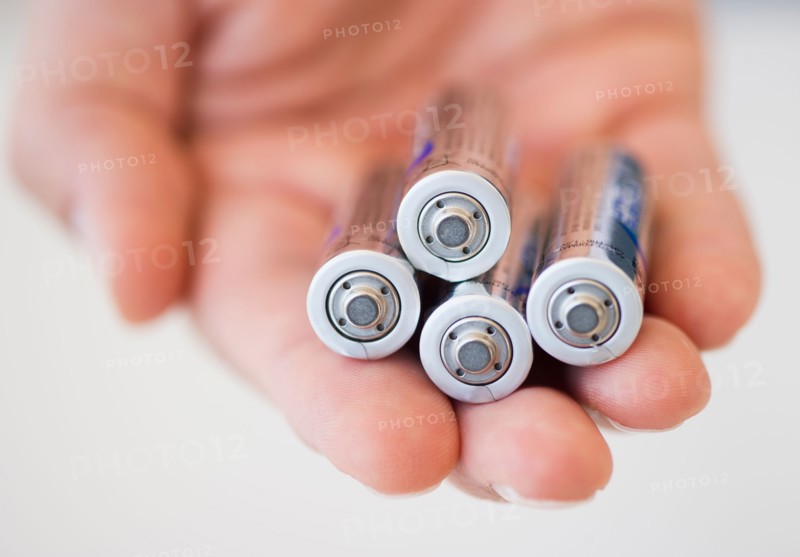 Hand holding batteries.