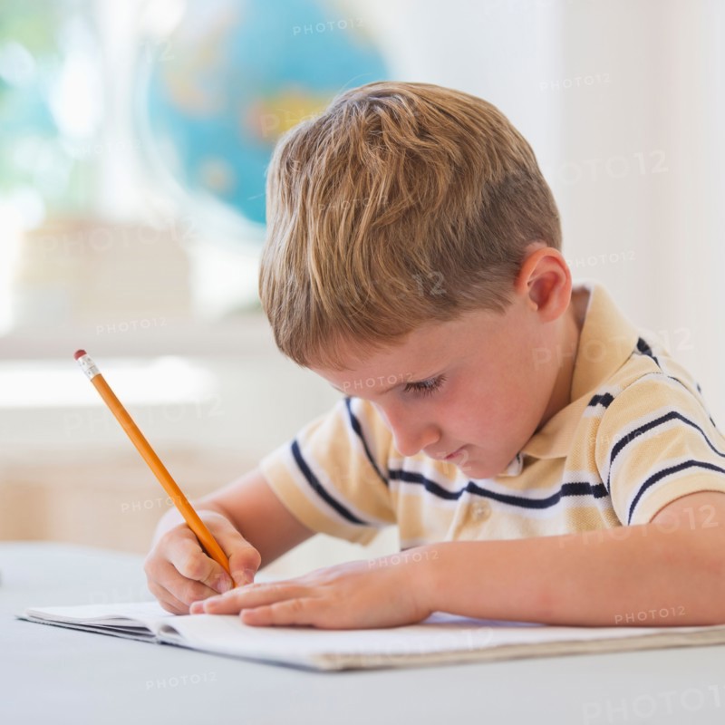 Close up of boy (4-5) writing in notebook. Photo: Daniel Grill