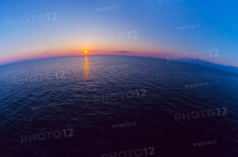 Aerial view of horizon over sea at sunrise.