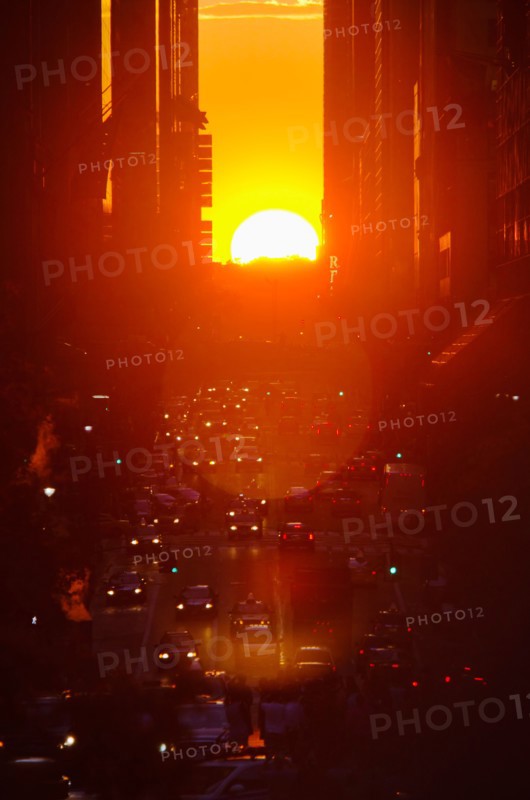 USA, New York, New York City, Sunset illuminating busy street.