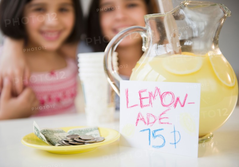 Close up of two girl's (8-9, 10-11) selling lemonade. Photo: Jamie Grill