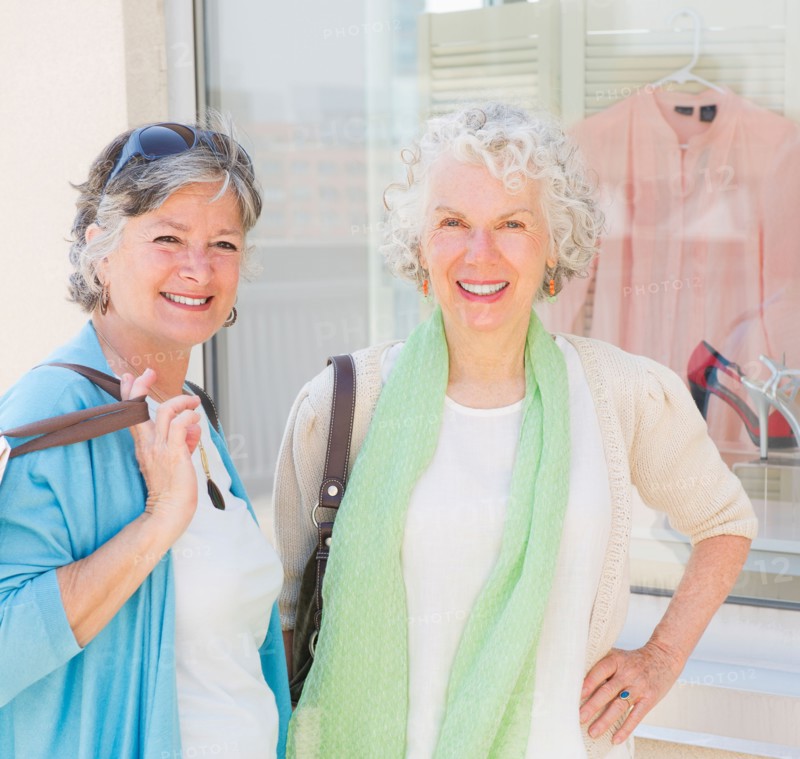 Two senior women standing in front of window display. Photo : Daniel Grill