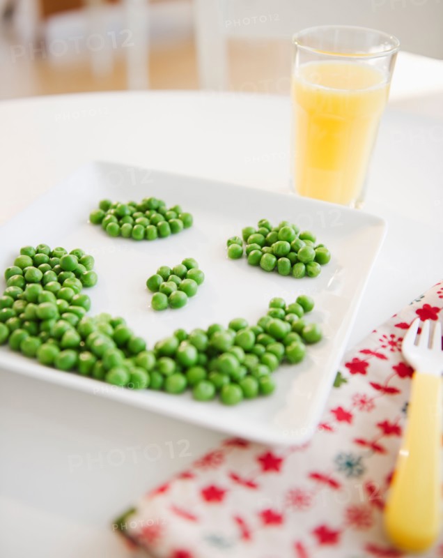 Close up of smiley on plate made of green peas. Photo : Jamie Grill