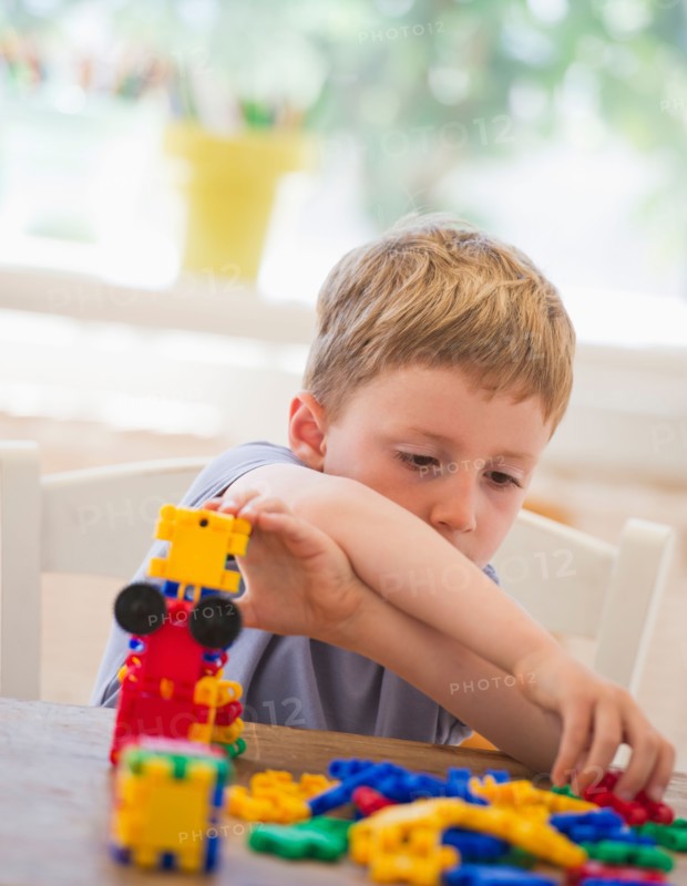 Close up of boy (4-5) playing with plastic blocks. Photo : Daniel Grill